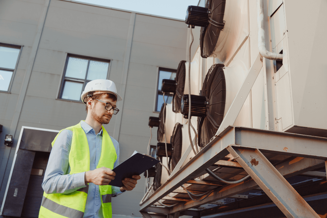 HVAC technician inspecting commercial air conditioning system showing signs of fault and wear in Dubai commercial building